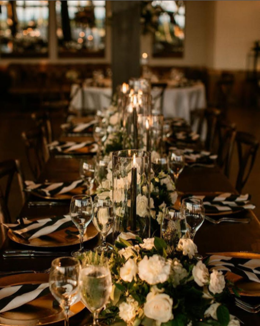 Art deco decoration on wedding reception table, black and white striped napkins, long black candles in glass candleholders