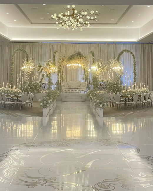 White and crystal wedding venue with high silver candles and white and gray decorations, white shiny floor