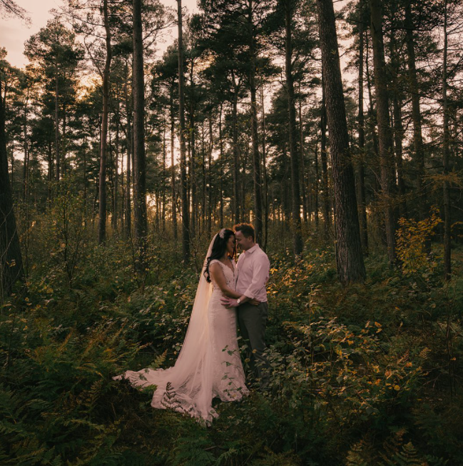 Wedding couple during the sunset in the forest surrounded by bushes and pine trees