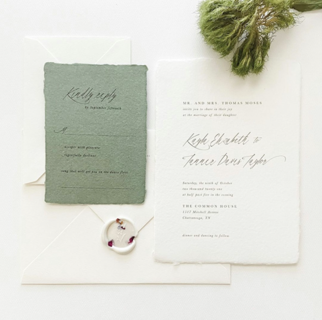 Green envelope wedding invitation and calligraphic invitation on structure paper