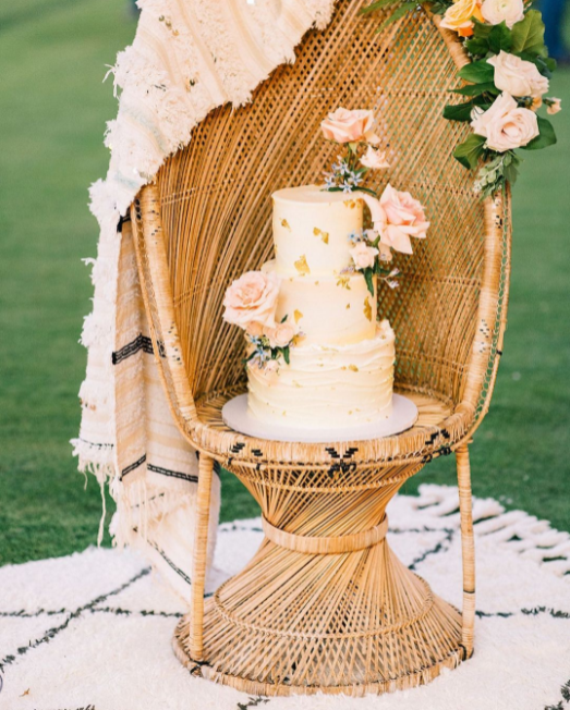 Pastel-colored wedding cake on the wicker chair
