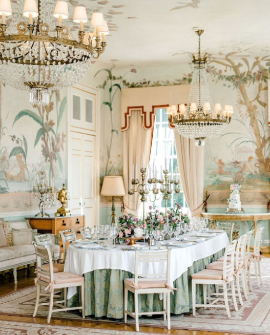 Palace interior in pastel shades, wedding table with golden candelabras, pink flowers
