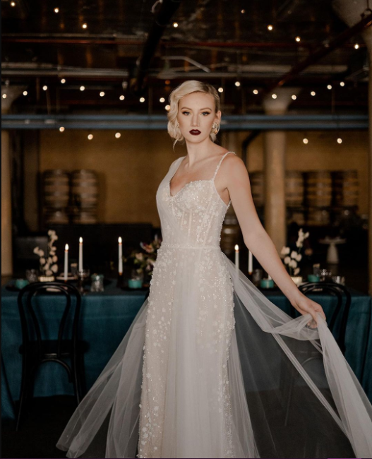 The Bride in asymmetric wedding dress with tulle, short blonde hair in classic hairstyle, dark lipstick shade