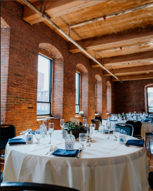 Bare, red brick walls, round tables covered in plain white tablecloth, nay blue napkins and chairs