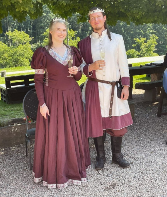 Wedding couple in medieval costumes with champagne glasses in their hands