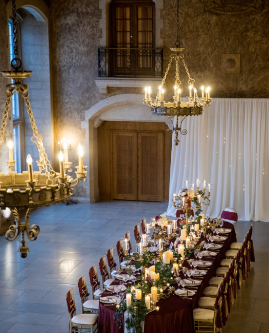 Palace interior with golden chandelier and long, richly decorated tables
