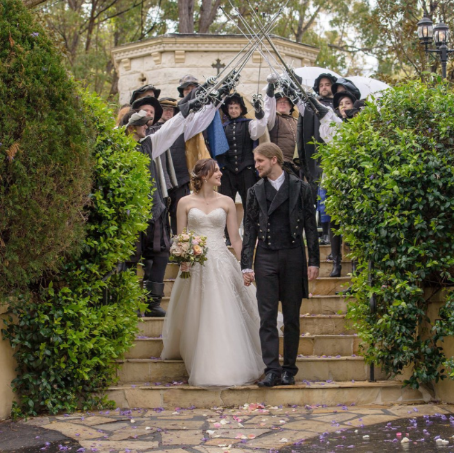 Wedding couple walking under the sword held by wedding guests