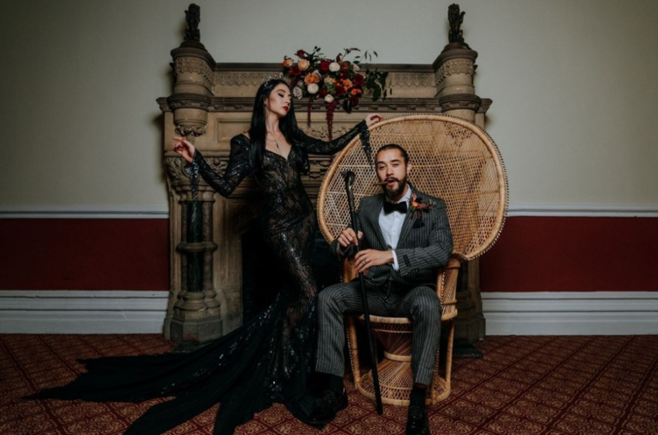 Wedding couple, the groom on the wicker chair, the bride in black wedding dress, the chimney in the back