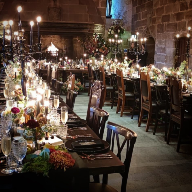 Castle interior, dark wood tables and chairs, candles