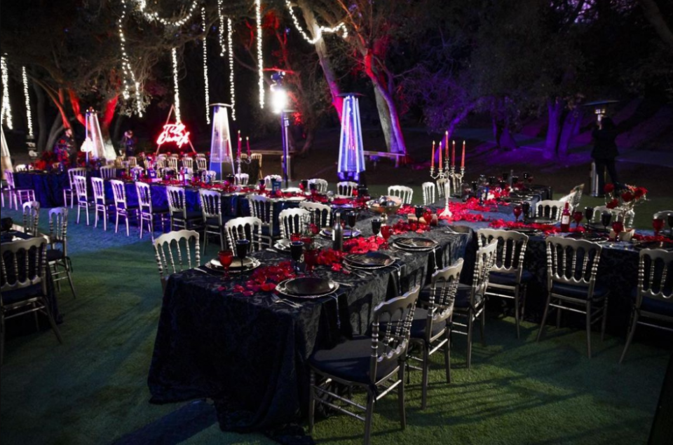 Black velvet tablecloths, rose petals, silver and black chairs, neon lights